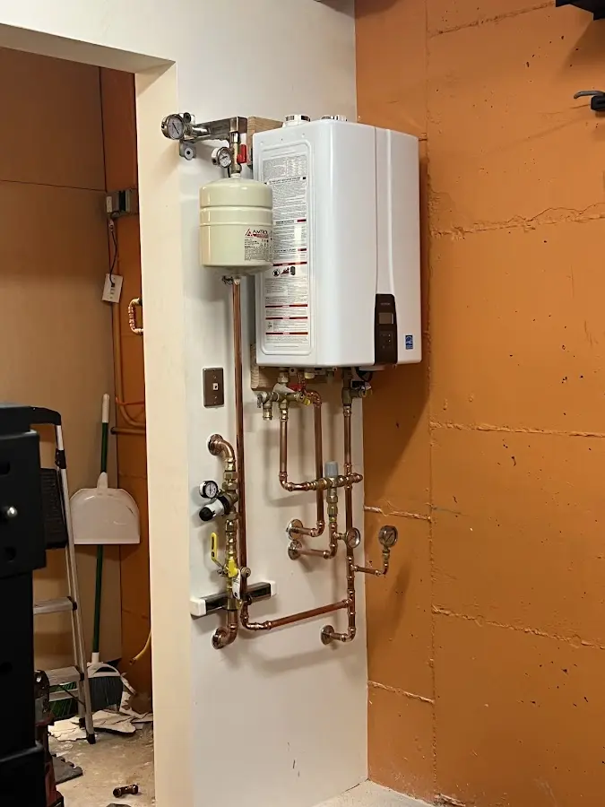 Plumbing technician inspecting water heater connections in Kayenta